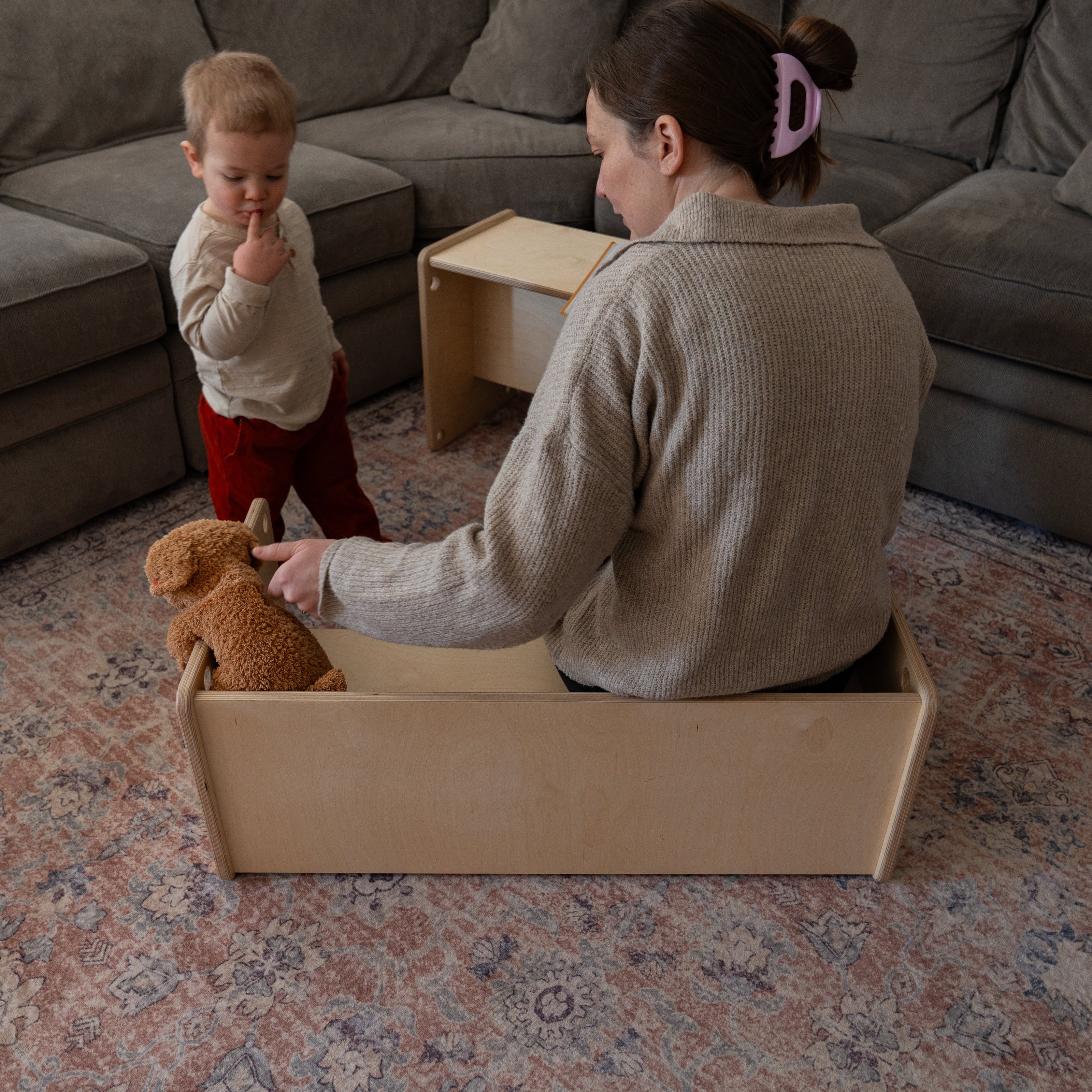Mom and toddler sitting on wooden bench converted from kids table in living room
